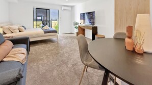 Un salon moderne avec un canapé, une table à manger et un téléviseur.