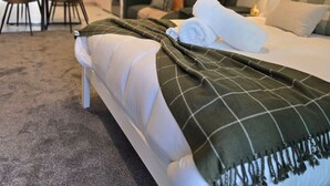 Ett modernt hotellrum med en säng, en matplats och ett kök.