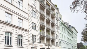 A multi-story building with balconies, parked cars, and a street view. - Blueground | Landstraße, balcony, nr Belvedere (Vienna)