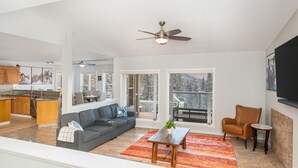A spacious living area with a gray sectional sofa, a coffee table, and a TV mounted on the wall. - 4,000 SF Luxury Home | 6-BR + 5-BA | 2-minute DRIVE to Jasper National Park (Jasper)