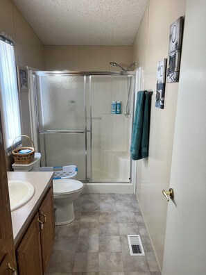 Un baño con inodoro, ducha y lavamanos.