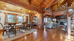Ein geräumiges Blockhaus-Interieur mit Essbereich, Wohnzimmer und Kamin.