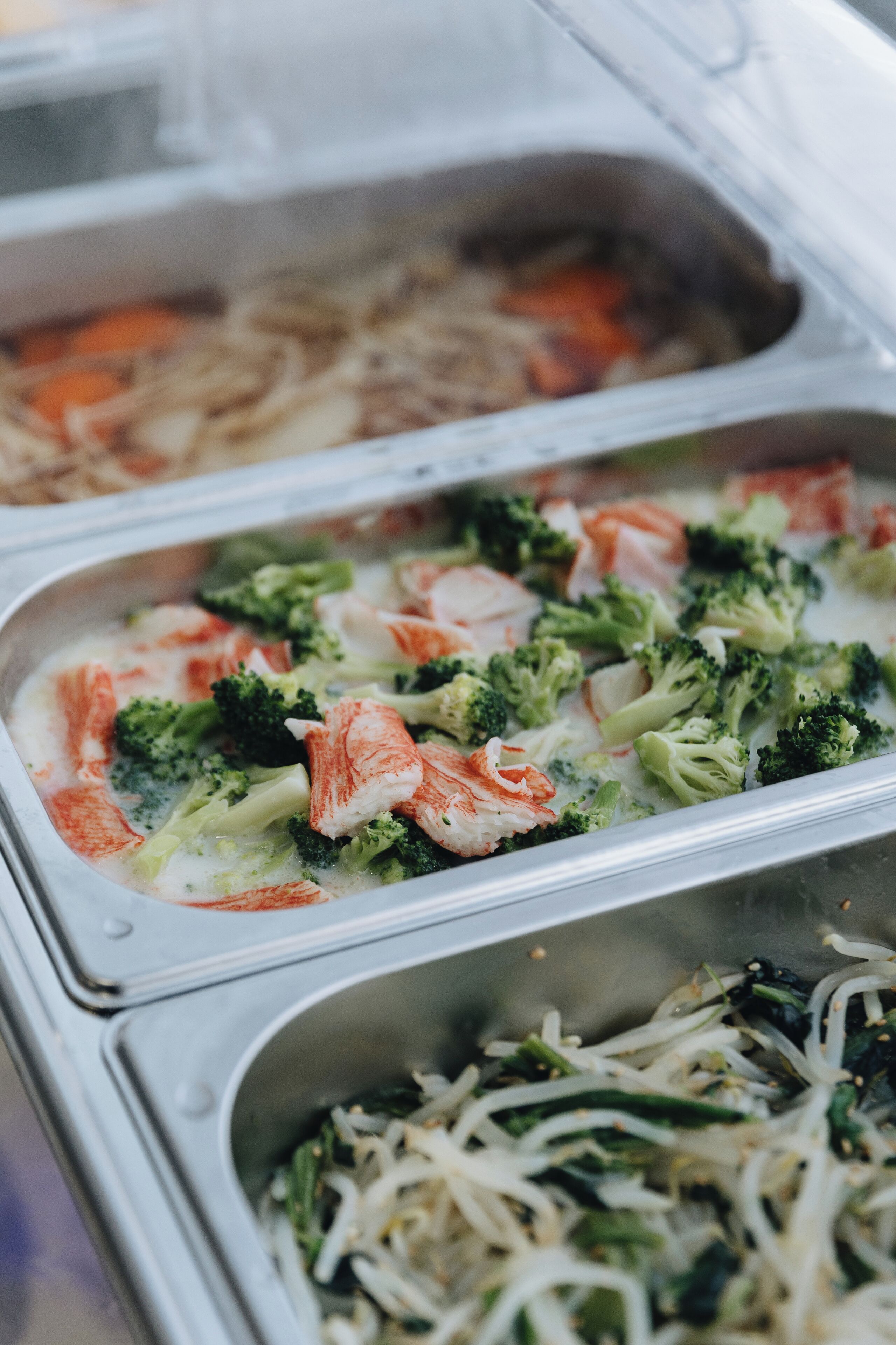 Un buffet proposant une variété de plats, notamment des fruits de mer et des légumes.