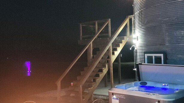 Uma banheira de hidromassagem, uma escadaria e um edifício à noite.