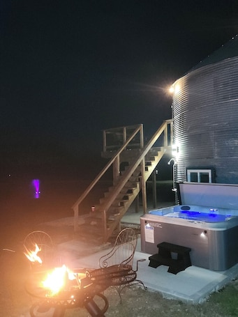A hot tub, a staircase, and a building at night.. Secluded Silo