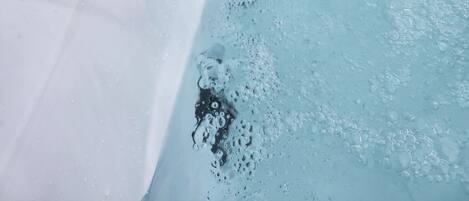 Un jacuzzi con chorros de agua, un panel de control y una zona de estar.