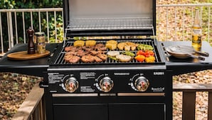 A black grill with multiple cooking zones and a side table with condiments. - Residential accommodation with barbecue in Nikko forest Forest Bird (日光市)