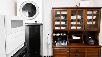 A laundry area with a washing machine, dryer, and wooden cabinet with storage baskets.