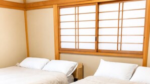 A room with two beds, a window with wooden frames, and an air conditioning unit. - Residential accommodation with barbecue in Nikko forest Forest Bird (日光市)