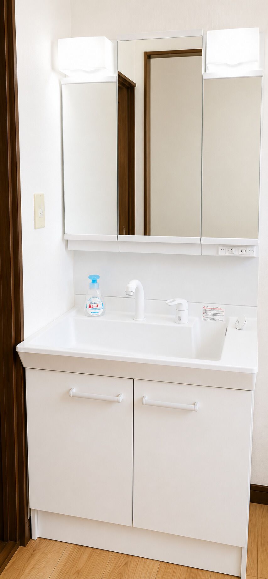 Un baño con lavamanos, espejo y mueble.