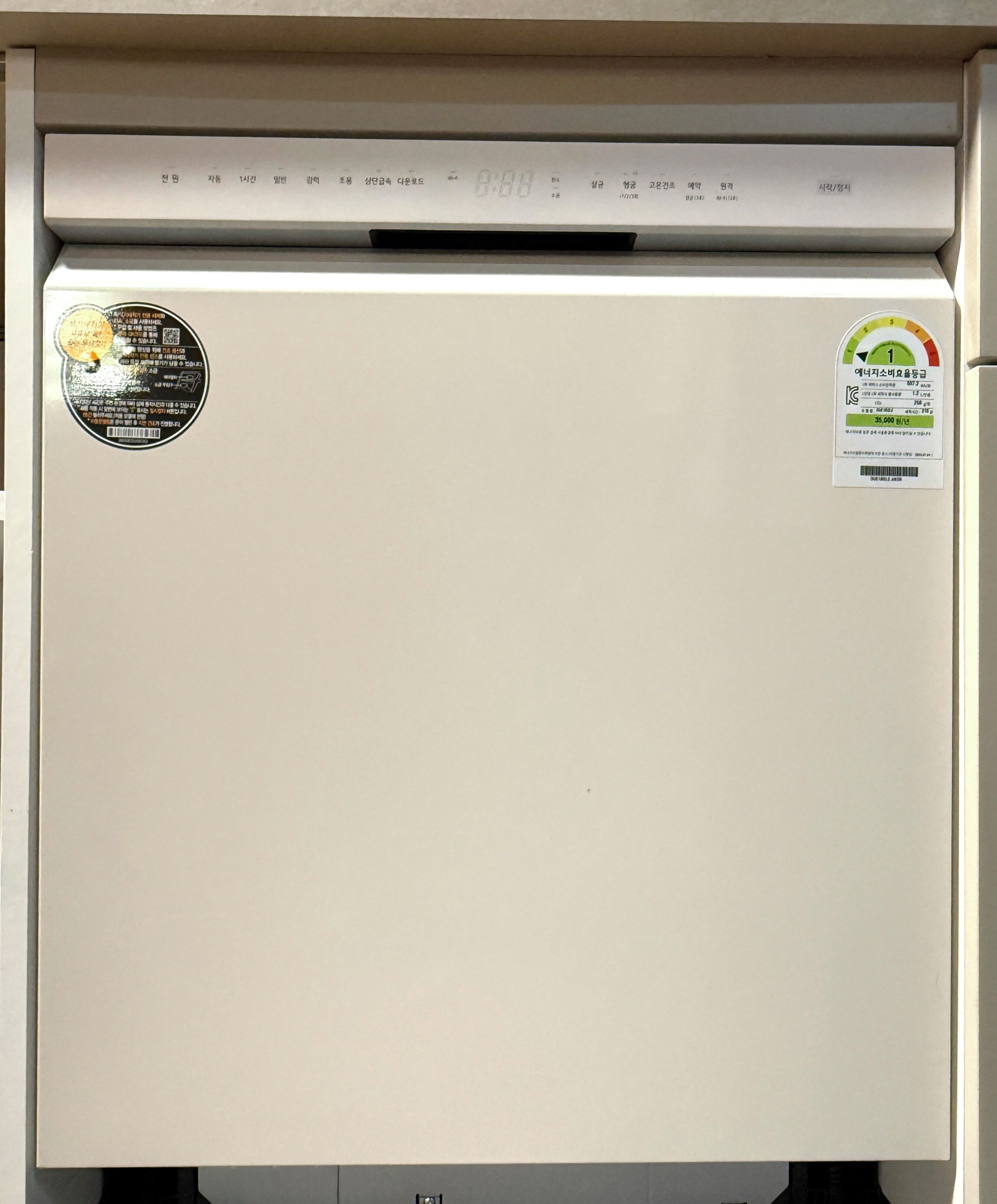 A refrigerator with a digital display and stickers.