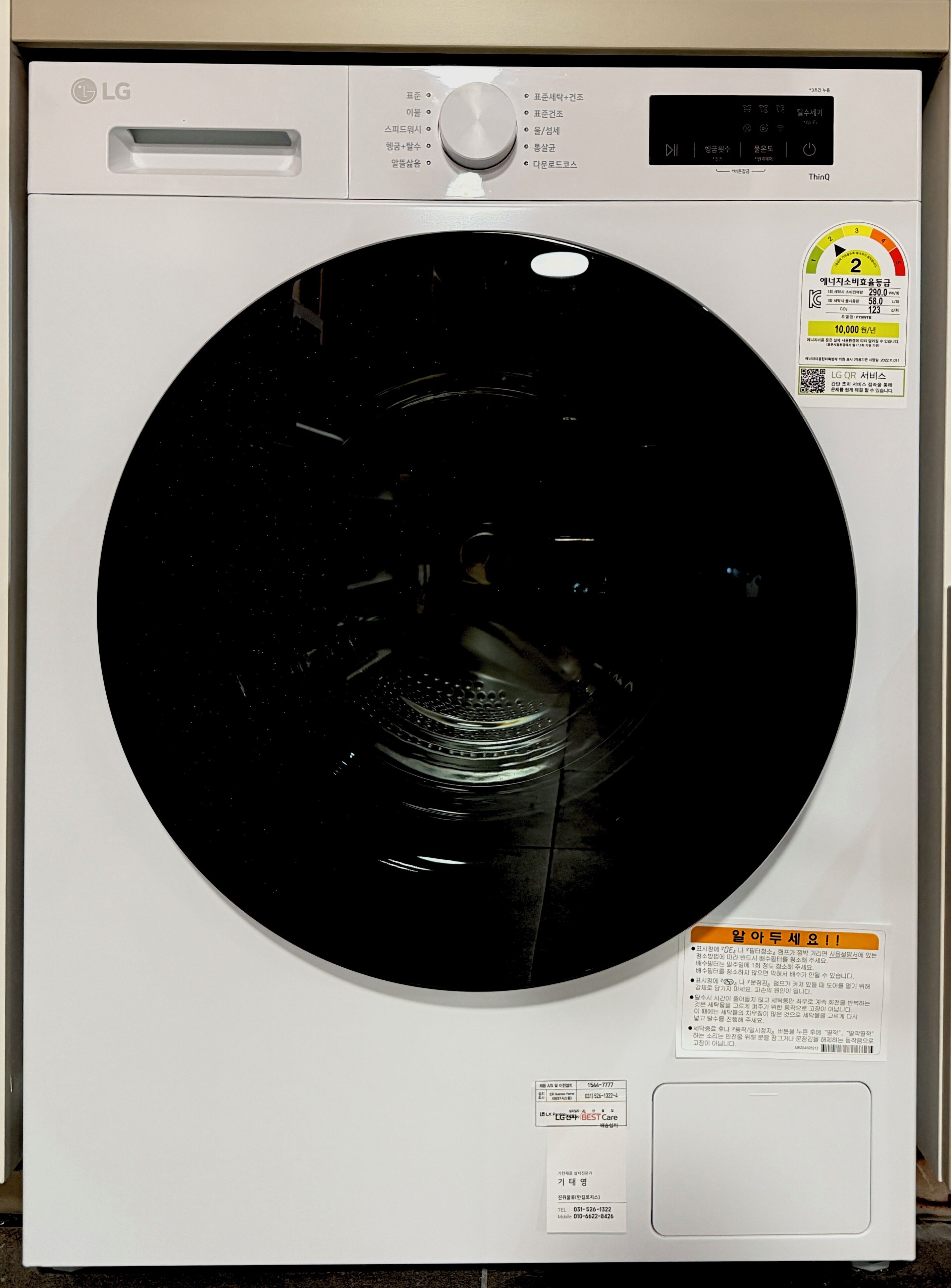 A white LG washing machine with a control panel, a digital display, and a circular drum.
