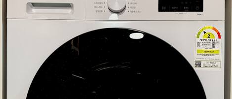 A white LG washing machine with a control panel, a digital display, and a circular drum.