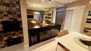 A modern kitchen with a central island, built-in appliances, and a dining area with a glass table. - Resort Parc Paradiso (Belem)
