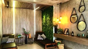 Un salon moderne avec un canapé, une petite table et un mur vert.