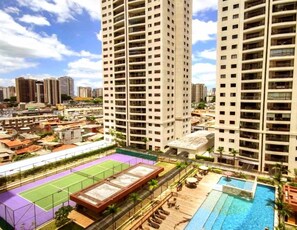 A high-rise building with multiple balconies, a rooftop tennis court, and a swimming pool. - Resort Parc Paradiso (Belem)