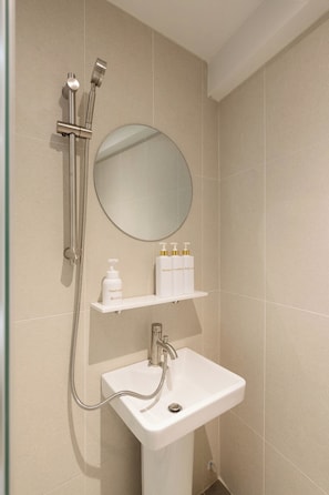 Standaard tweepersoonskamer | Badkamer | Een douche, een haardroger, handdoeken, zeep