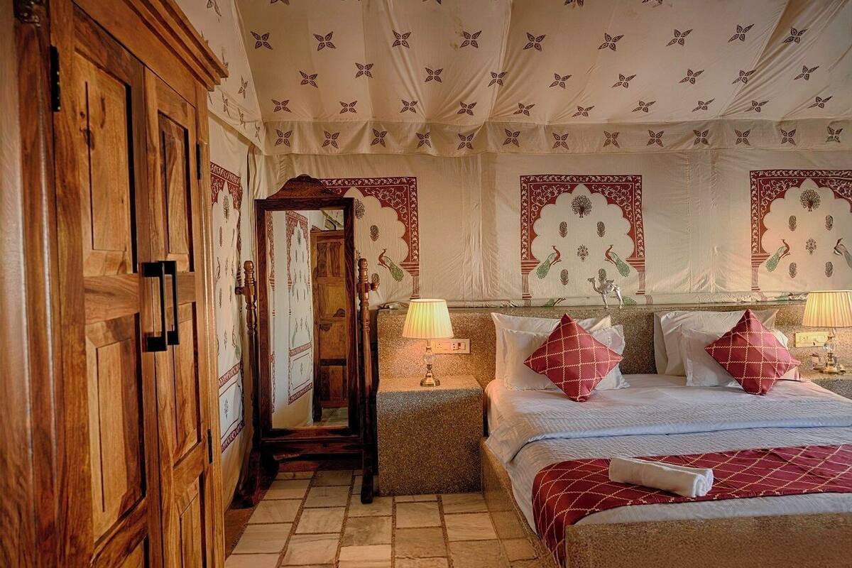 Una camera tradizionale con un armadio in legno, un letto con biancheria rossa e bianca e decorazioni murali decorate.
