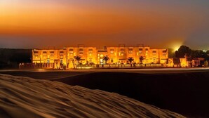 A hotel with multiple stories, a prominent entrance, and a well-lit facade. - Desert Valley Resort (Jaisalmer)