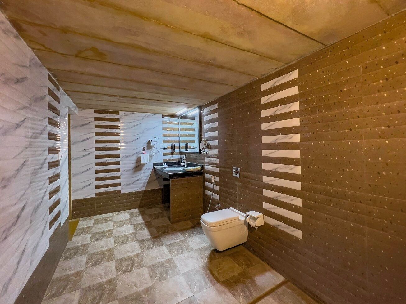 Un baño pequeño con tocador de mármol, inodoro y lavamanos.