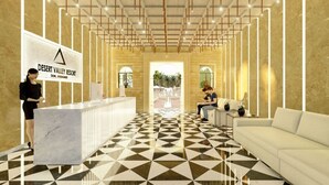 A reception area with a check-in counter, a white sofa, and a patterned floor. - Desert Valley Resort (Jaisalmer)