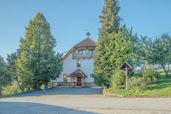 A two-story building with a balcony, a small porch, and a driveway leading to the entrance. - Farm Stay Oblak 1BR Apt Nataša + Shared Sauna, Ortnek, Slovenia (Ortnek)