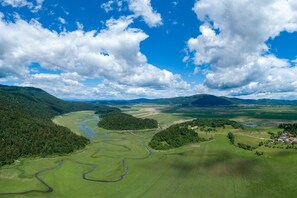 A panoramic view of a landscape with a river, forested areas, and a small settlement. - Oblak Estate Studio Ina, Ortnek, Slovenia (Ortnek)