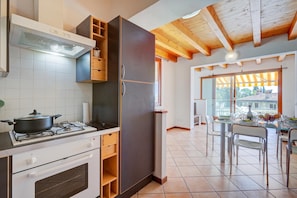 A kitchen with a stove, oven, and a refrigerator. There is a dining area with a table and chairs.