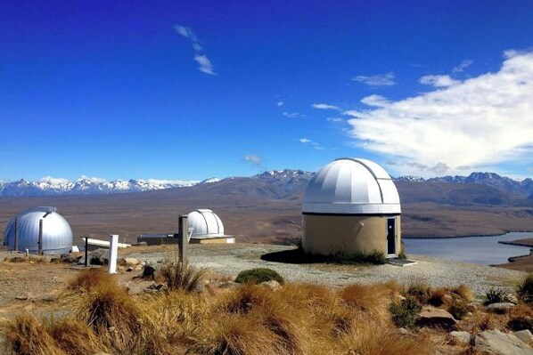 A remote observatory with domed structures and a clear view of mountains in the background. - Tekapo1929 Lakefront Villa (Lake Tekapo)