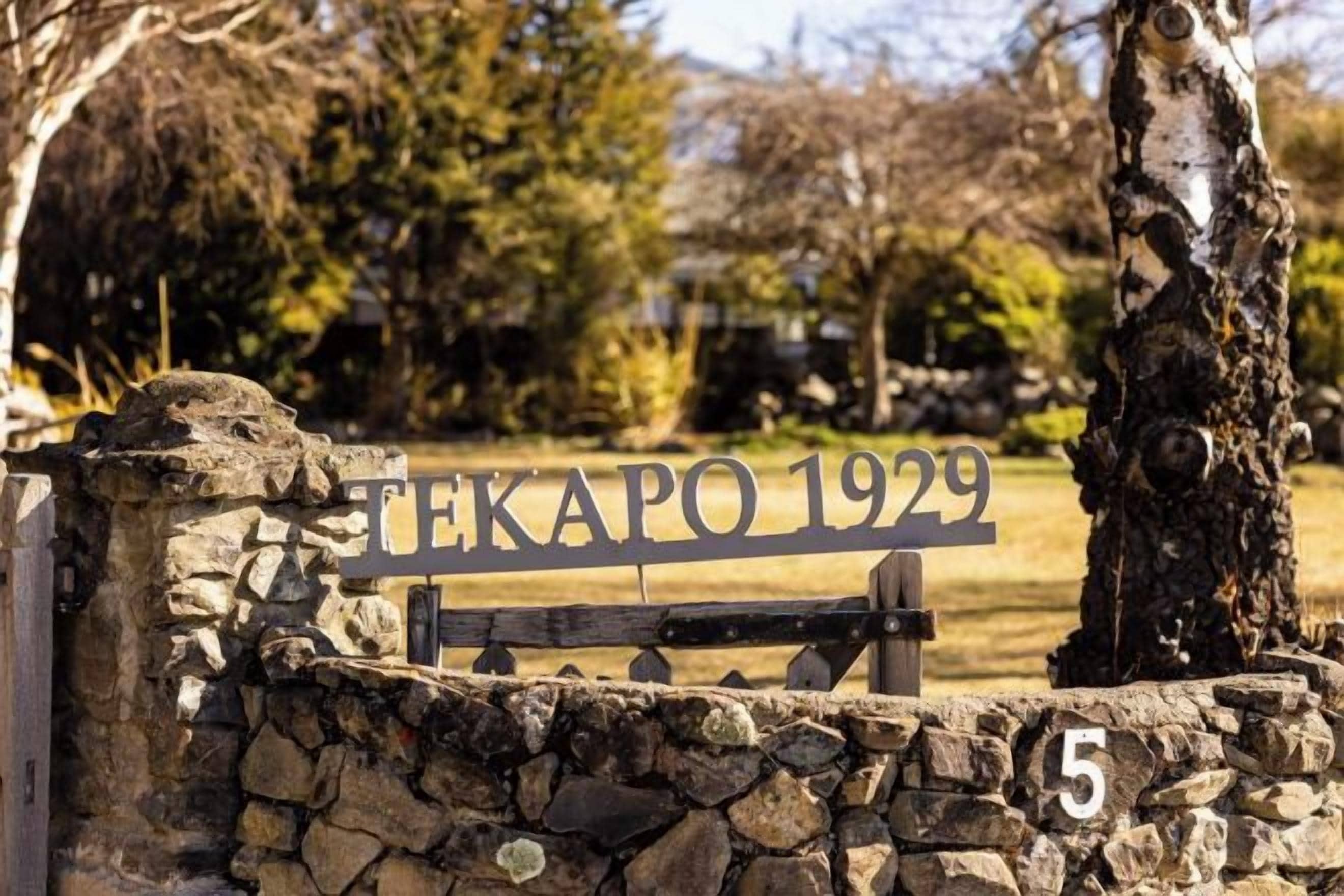 Eine Steinsäule mit einem Metallgitter und einem Schild, auf dem 'TEKAPO 1929' steht.