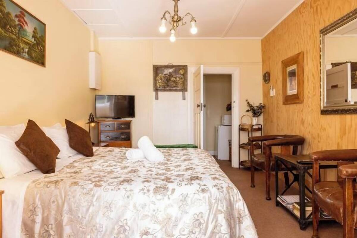 Une chambre d’hôtel équipée d’un lit, d’une télévision, d’un bureau et d’une chaise.