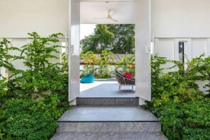 A pathway leading to a seating area with a ceiling fan, surrounded by greenery. - Villa Lady Blue, 3 Bedrooms (Koh Samui)