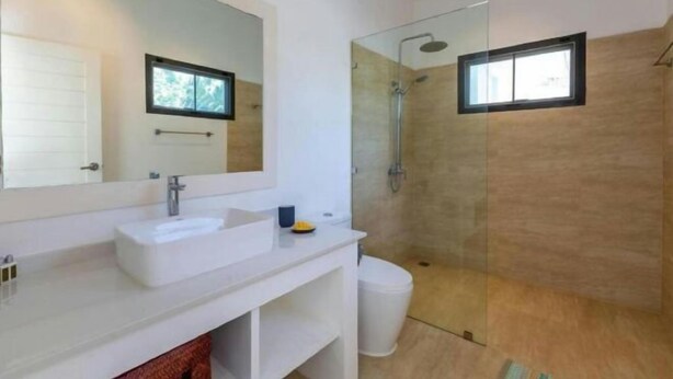 A modern bathroom with a large mirror, a white sink, a glass-enclosed shower, and a toilet. - Villa Lady Blue, 3 Bedrooms (Koh Samui)