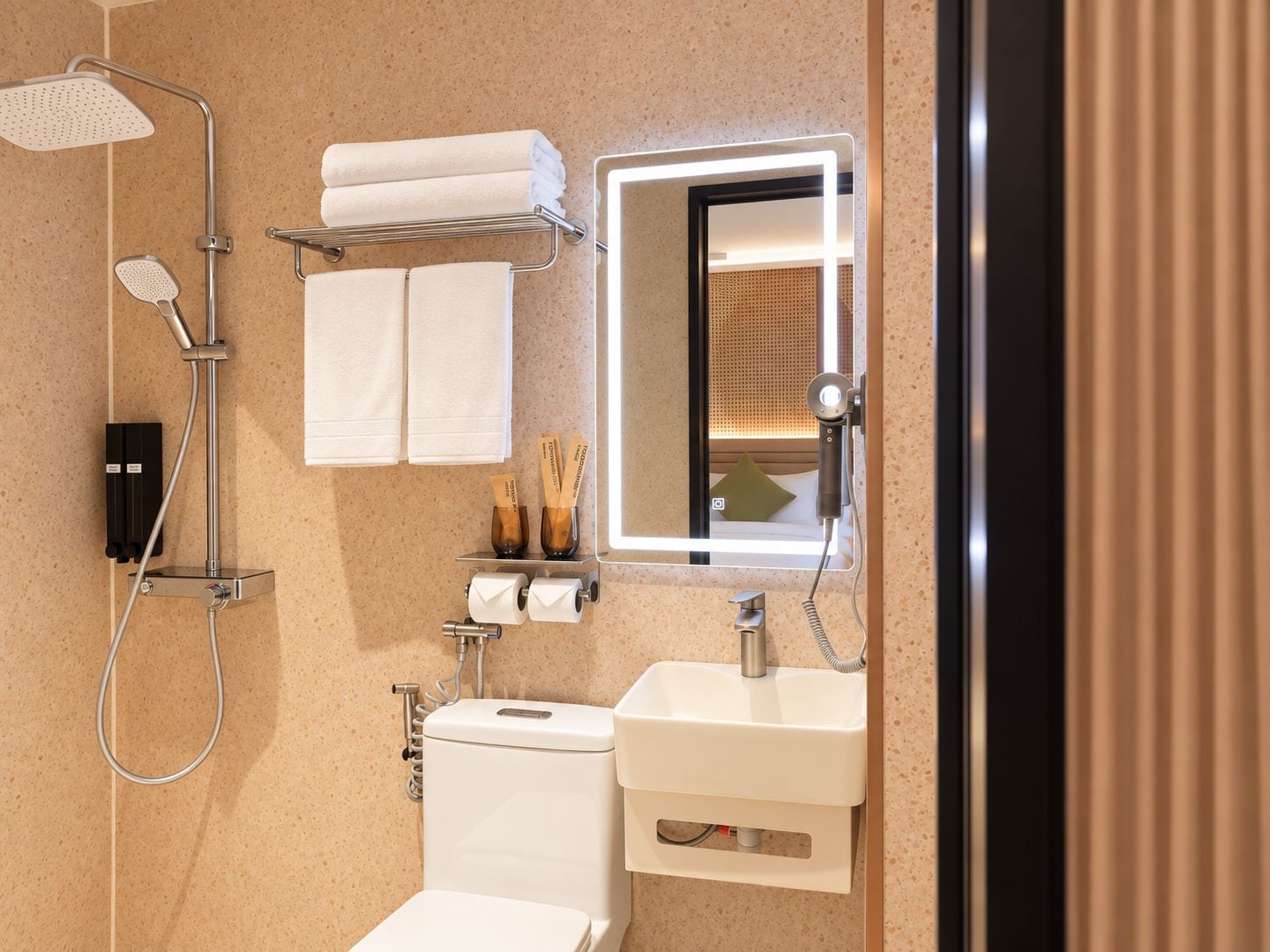 A modern bathroom with a shower, toilet, sink, and a mirror with integrated lighting.