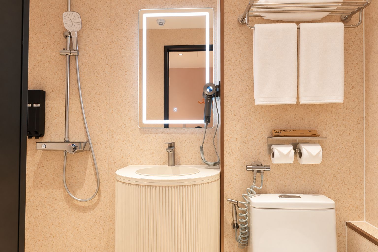 Ein Badezimmer mit Dusche, Waschbecken, Spiegel, Handtuchhalter und Toilettenpapierhalter.