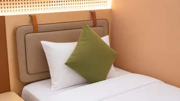 Una cama con cabecera, almohada y mesita de noche.