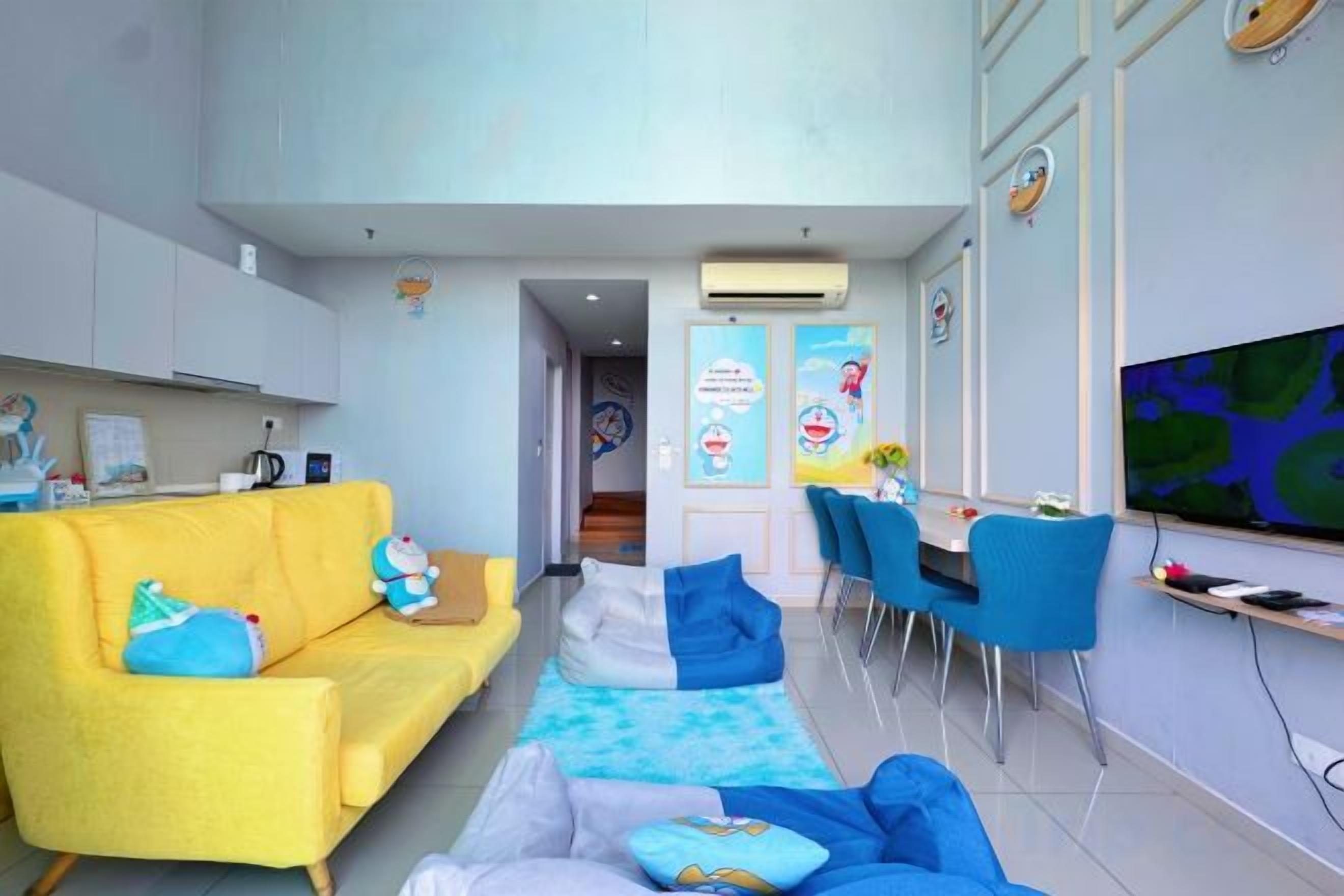 A modern living room with a yellow sofa, blue chairs, and a flat-screen TV.