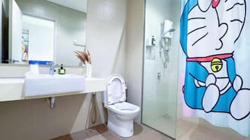 Un baño con inodoro, lavamanos y cabina de ducha de vidrio.