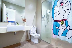 Une salle de bain équipée de toilettes, d’un lavabo et d’une douche à parois en verre.