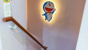Una escalera con barandilla y un aplique con un personaje de caricatura.