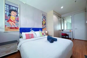 Une chambre avec un lit, un bureau et une chaise. Il y a un grand miroir au mur.