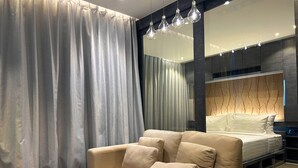 A modern bedroom with a sofa, a bedside table, and a bed. - 1BR with Rooftop Pool & Gym  C191 (Kamala)