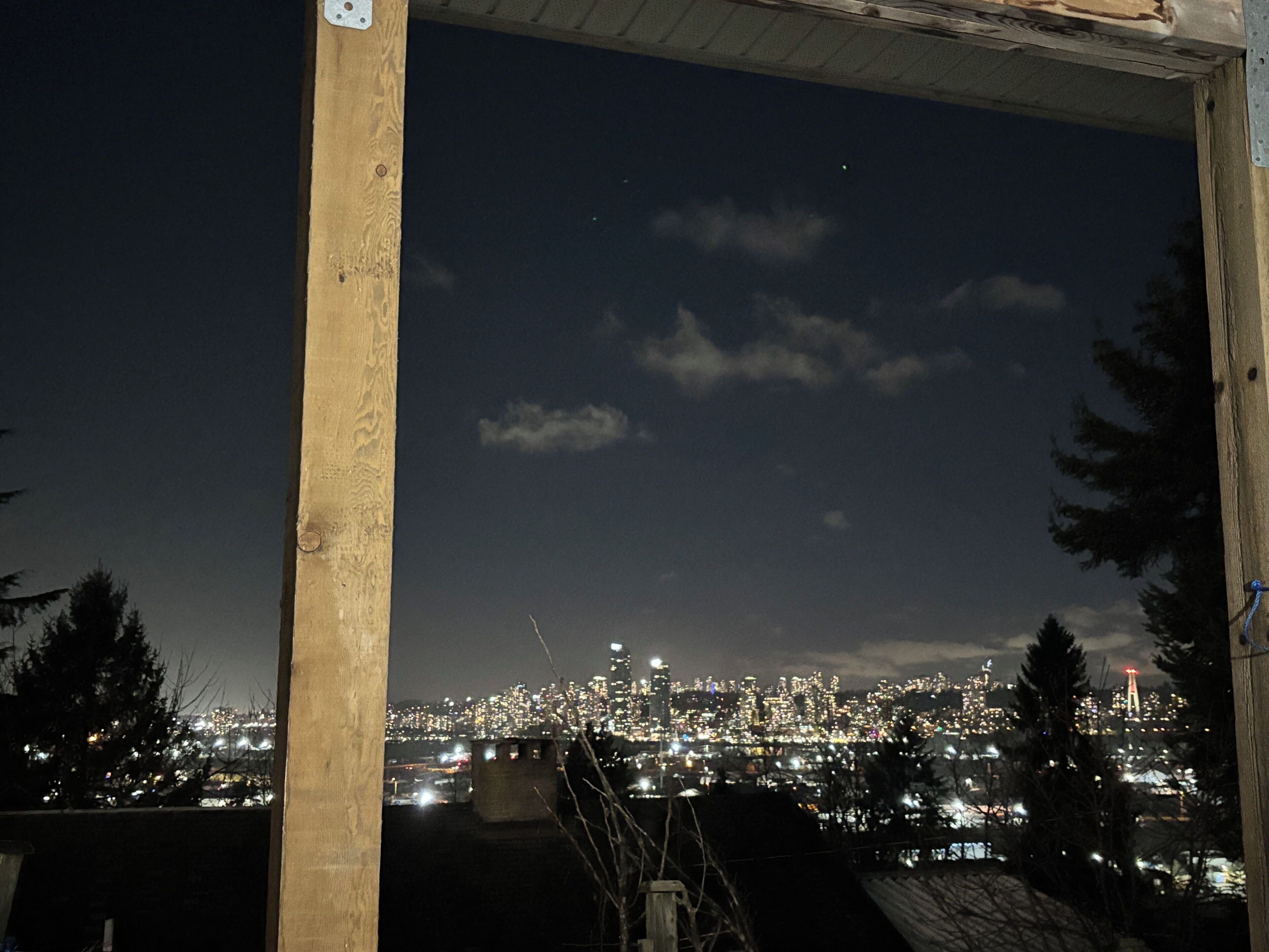 Ein nächtlicher Stadtblick von einer Holzkonstruktion mit Metallbefestigung.