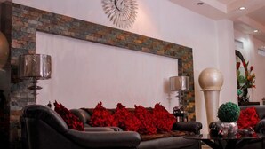 Un salon avec une cheminée, un canapé, une table basse et une horloge au mur.