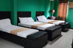 Una habitación de hotel con dos camas, una mesita de noche y una lámpara.