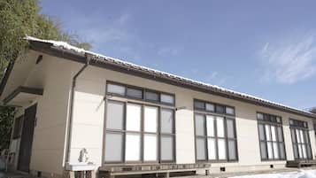 A building with large windows, a flat roof, and a snow-covered ground.