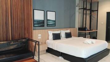 Una habitación de hotel moderna con una cama, un banco de madera y una pequeña mesa.