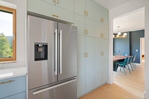 Eine moderne Küche mit einem Edelstahlkühlschrank, eingebauten Schränken und einem Wasserspender.