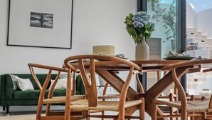 A modern dining area with a round table, wooden chairs, a ceiling fan, and pendant lights. - New Magnificent 3BR 5min to Finns & Berawa Beach Villa Alemar (Bali)