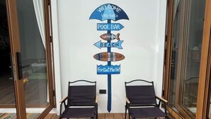 Eine Wand mit einem Wegweiser, der Annehmlichkeiten wie Poolbar, Strand und Sand-Surf-Spaß auflistet.